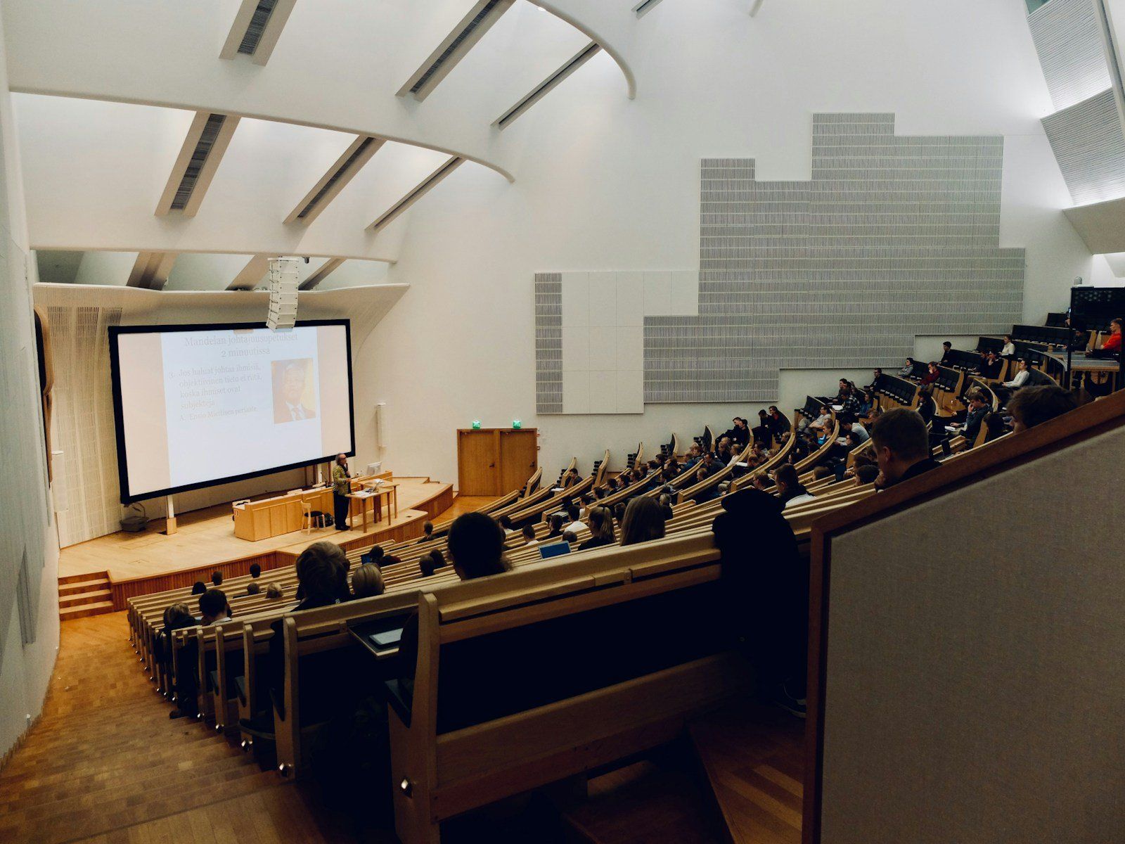 Students in a lecture hall facing a projection screen