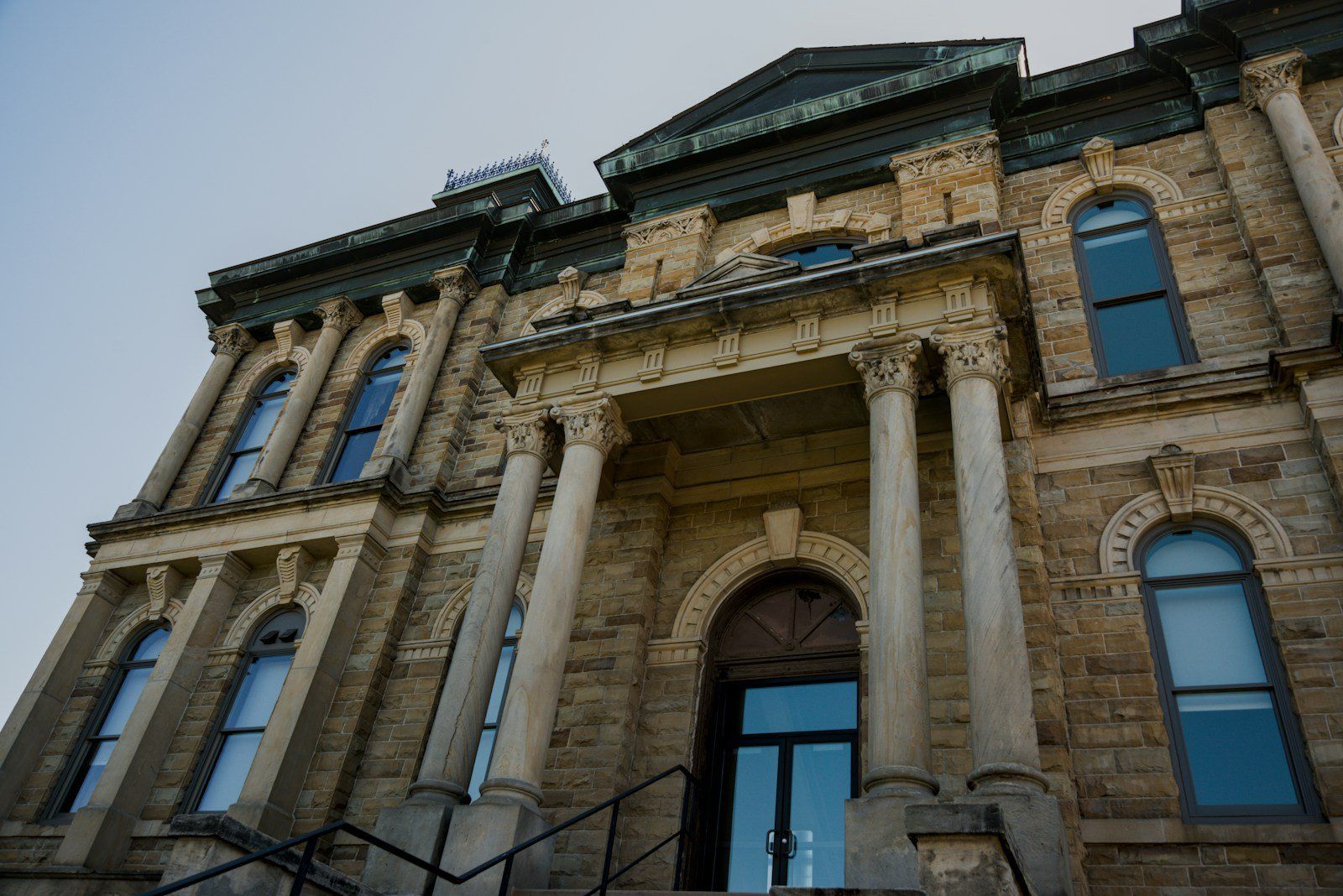 Stone government building with columns and arched windows